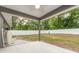 Covered patio overlooking a fenced yard with trees and a green lawn at 7101 Se 124Th St, Belleview, FL 34420
