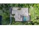 Aerial view of a home showcasing a large pool and a screen enclosure with lush greenery at 725 Bear Creek Cir, Winter Springs, FL 32708