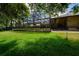 Expansive backyard view featuring a screened-in pool, patio, and green lawn at 725 Bear Creek Cir, Winter Springs, FL 32708