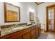 A bathroom with double sinks, wood cabinetry, granite countertops, and access to a pool at 725 Bear Creek Cir, Winter Springs, FL 32708
