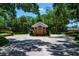 Community entrance featuring a charming brick gatehouse and manicured landscaping at 725 Bear Creek Cir, Winter Springs, FL 32708