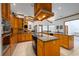A large kitchen showcases granite countertops, an island with cooktop, and custom wood cabinetry at 725 Bear Creek Cir, Winter Springs, FL 32708