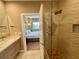 Bathroom featuring glass shower with custom tilework and a view to Primary bedroom at 7458 Brooklyn Dr, Kissimmee, FL 34747