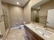 Bathroom featuring double sinks, modern fixtures, and a glass-enclosed shower at 7458 Brooklyn Dr, Kissimmee, FL 34747