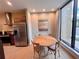 Cozy dining area near a large window, featuring a round table and stainless steel refrigerator at 7458 Brooklyn Dr, Kissimmee, FL 34747