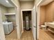 Hallway with water heater closet and a laundry room on one side and a bathroom on the other at 7458 Brooklyn Dr, Kissimmee, FL 34747