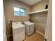 Well-lit laundry room with modern washer and dryer and convenient shelving at 7458 Brooklyn Dr, Kissimmee, FL 34747