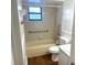 Bathroom featuring shower/tub combo with safety bars, toilet and tile walls at 7540 Govern Blvd, Orlando, FL 32822