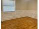 Spacious room with hardwood floors, wainscoting detail, and natural lighting at 7540 Govern Blvd, Orlando, FL 32822
