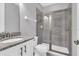 Bright bathroom features a glass shower, granite countertop, and modern finishes at 7584 Marker Ave, Kissimmee, FL 34747