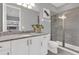 Bright bathroom includes a glass shower, granite countertop, and white vanity at 7584 Marker Ave, Kissimmee, FL 34747