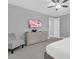 Well-lit bedroom featuring a ceiling fan, chair, and television above a dresser at 7584 Marker Ave, Kissimmee, FL 34747