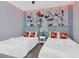 Charming bedroom with two beds, Mickey Mouse themed wall art, and ceiling fan at 7584 Marker Ave, Kissimmee, FL 34747
