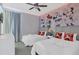 Charming bedroom with two beds, Mickey Mouse themed wall art, and ceiling fan at 7584 Marker Ave, Kissimmee, FL 34747