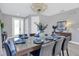 Dining room with a long table, modern chandelier, and decorative blue vase with floral arrangement at 7584 Marker Ave, Kissimmee, FL 34747