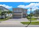 Two story home featuring a neutral color scheme, paved drive and manicured landscaping at 7584 Marker Ave, Kissimmee, FL 34747