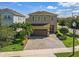 Two story home featuring a neutral color scheme, paved drive and mature trees at 7584 Marker Ave, Kissimmee, FL 34747