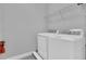Practical laundry room with a washer, dryer, and shelving for storage at 7584 Marker Ave, Kissimmee, FL 34747