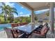Inviting outdoor dining area next to a sparkling pool and lush tropical landscaping at 7584 Marker Ave, Kissimmee, FL 34747