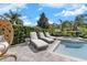 Backyard pool and spa area with lounge chairs, privacy landscaping and a modern, designer hanging chair at 7584 Marker Ave, Kissimmee, FL 34747