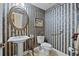 Powder room featuring decorative wallpaper, round mirror and pedestal sink at 7957 S Park Pl, Orlando, FL 32819