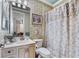 Charming bathroom with decorative wallpaper, vanity sink, and shower with patterned curtain at 7957 S Park Pl, Orlando, FL 32819