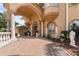 Covered entrance featuring grand architecture, stone columns and elegant hardscaped driveway at 7957 S Park Pl, Orlando, FL 32819