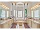Elegant main bathroom featuring dual sinks, patterned wallpaper, marble tile floor, and soaking tub with columns at 7957 S Park Pl, Orlando, FL 32819