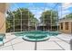 A screened-in pool with a jacuzzi, surrounded by lush landscaping and ample patio space at 7957 S Park Pl, Orlando, FL 32819