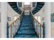 Grand foyer with a sweeping staircase featuring intricate railing details and carpeted steps at 7957 S Park Pl, Orlando, FL 32819