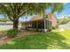 Spacious backyard with a screened-in patio, lush green grass, and mature trees at 905 N Lake Claire Cir, Oviedo, FL 32765