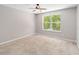 Empty bedroom featuring a ceiling fan, carpet flooring, and natural lighting from the window at 905 N Lake Claire Cir, Oviedo, FL 32765