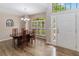 Well-lit dining room featuring wood floors, a chandelier, large windows, and a view of the front yard at 905 N Lake Claire Cir, Oviedo, FL 32765