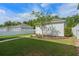 A spacious backyard featuring green lawn, partial fence, and a detached garage at 908 Tilden Oaks Trl, Winter Garden, FL 34787