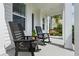 Cozy front porch featuring rocking chairs and a swing, perfect for relaxing outdoors at 908 Tilden Oaks Trl, Winter Garden, FL 34787