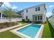 Beautiful backyard features a modern rectangular pool with a small lawn, and a white two-story home at 908 Tilden Oaks Trl, Winter Garden, FL 34787