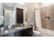 Stylish bathroom featuring granite counters, dark cabinetry, and shower over tub with tile surround at 9255 Doherty Pl, Orlando, FL 32827