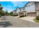 Exterior view of townhomes featuring garages, neutral paint and nicely landscaped yards at 9255 Doherty Pl, Orlando, FL 32827