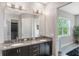 Well-lit main bathroom with double sink vanity, granite countertop, and large mirror at 9255 Doherty Pl, Orlando, FL 32827