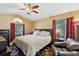Spacious main bedroom with large windows, a ceiling fan, and warm, neutral decor at 97 Desiree Aurora St, Winter Garden, FL 34787