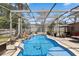 Inviting screened pool with rock waterfall feature and landscaped surroundings at 97 Desiree Aurora St, Winter Garden, FL 34787