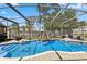 A screened pool with a rock waterfall feature in a well landscaped backyard at 97 Desiree Aurora St, Winter Garden, FL 34787