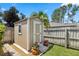 A backyard shed with fresh paint, positioned next to a well-manicured lawn at 97 Desiree Aurora St, Winter Garden, FL 34787