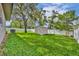 Landscaped backyard with green grass, storage shed, mature trees, an air conditioner, and white fencing at 1005 Turkey Hollow Cir, Winter Springs, FL 32708