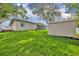 Lush backyard featuring a storage shed, mature trees, green grass, and the rear exterior of the home at 1005 Turkey Hollow Cir, Winter Springs, FL 32708