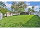 Spacious backyard with a storage shed, an enclosed patio, lush greenery, a pristine fence and mature trees at 1005 Turkey Hollow Cir, Winter Springs, FL 32708