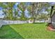 Well-maintained backyard featuring a shed, lush green grass, a pristine white fence, and mature shade trees at 1005 Turkey Hollow Cir, Winter Springs, FL 32708