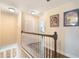 Well-lit upstairs hallway showcasing artwork and access to various rooms in the home at 1065 Clifton Springs Ln, Winter Springs, FL 32708