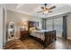 Cozy main bedroom with a tray ceiling, ceiling fan, and a full-length mirror at 1065 Clifton Springs Ln, Winter Springs, FL 32708