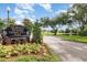 Community park sign at Alafaya Woods featuring lush landscaping and a pond at 1096 Dees Dr, Oviedo, FL 32765